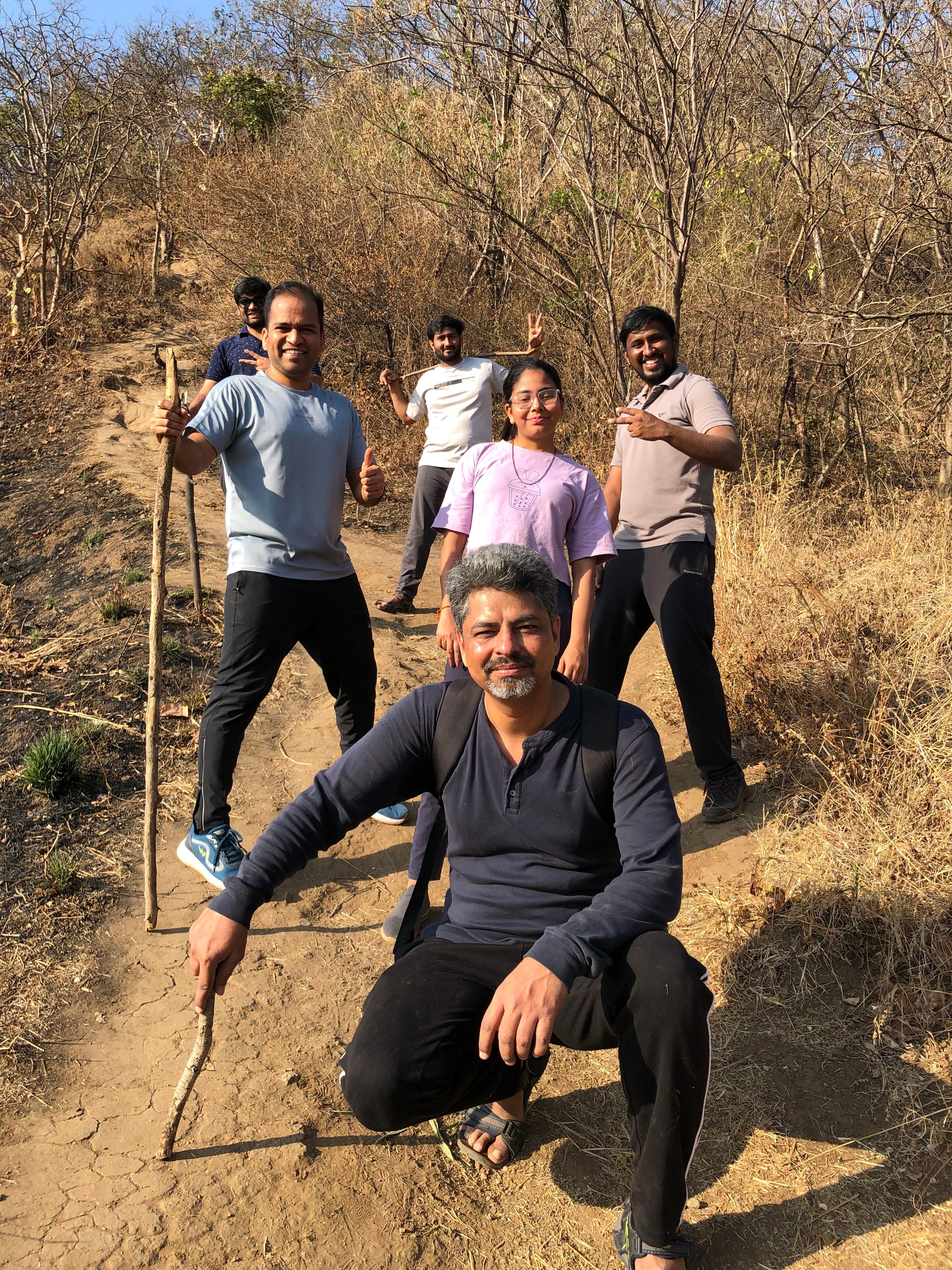 Team members posing on a dusty hiking trail